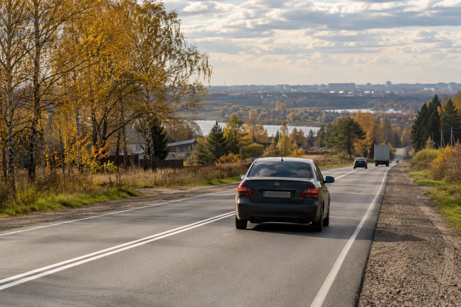 Двухполосная загородная дорога с двойной сплошной разметкой и машиной впереди